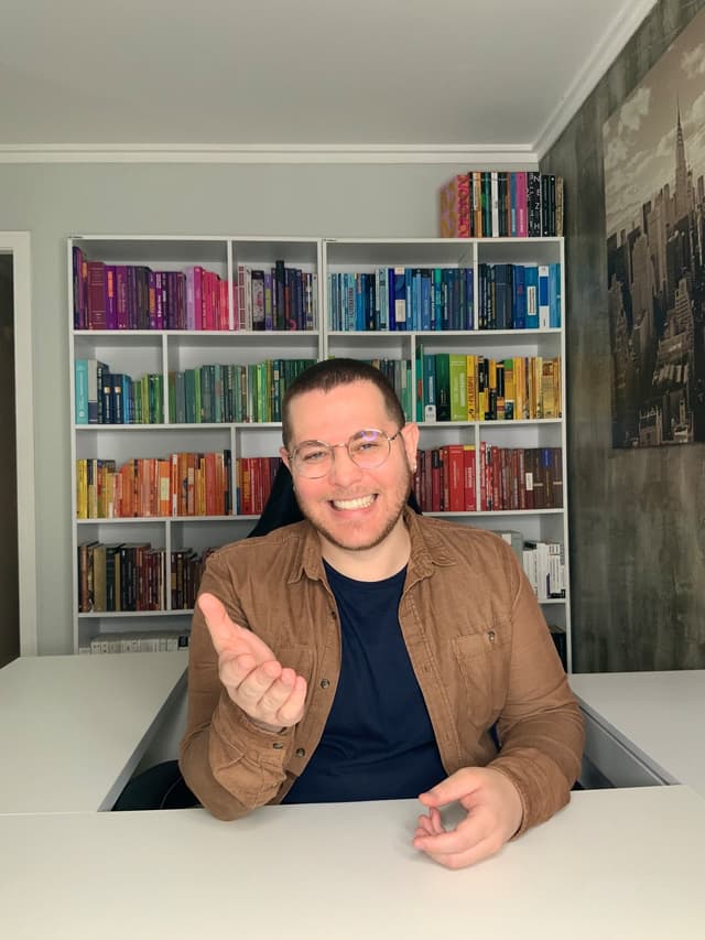 Professor Diego Hilarino em frente à estante de livros